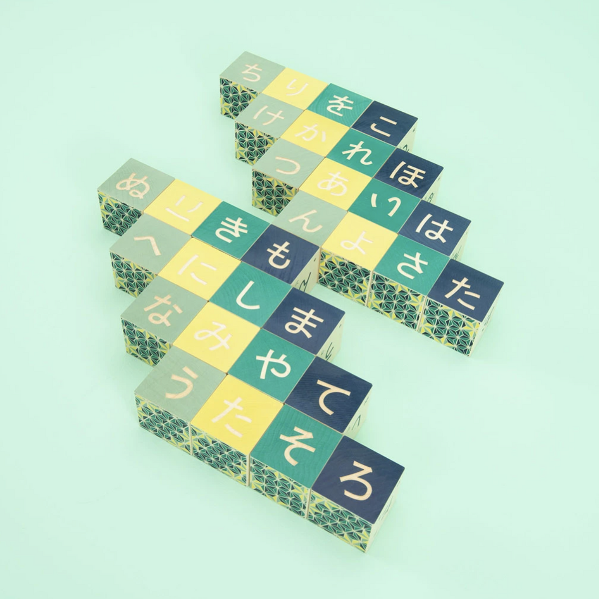 Colorful wooden blocks with Japanese text and patterns on a green background