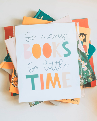 A pile of books with a print saying "So many Books, so little Time" on top.