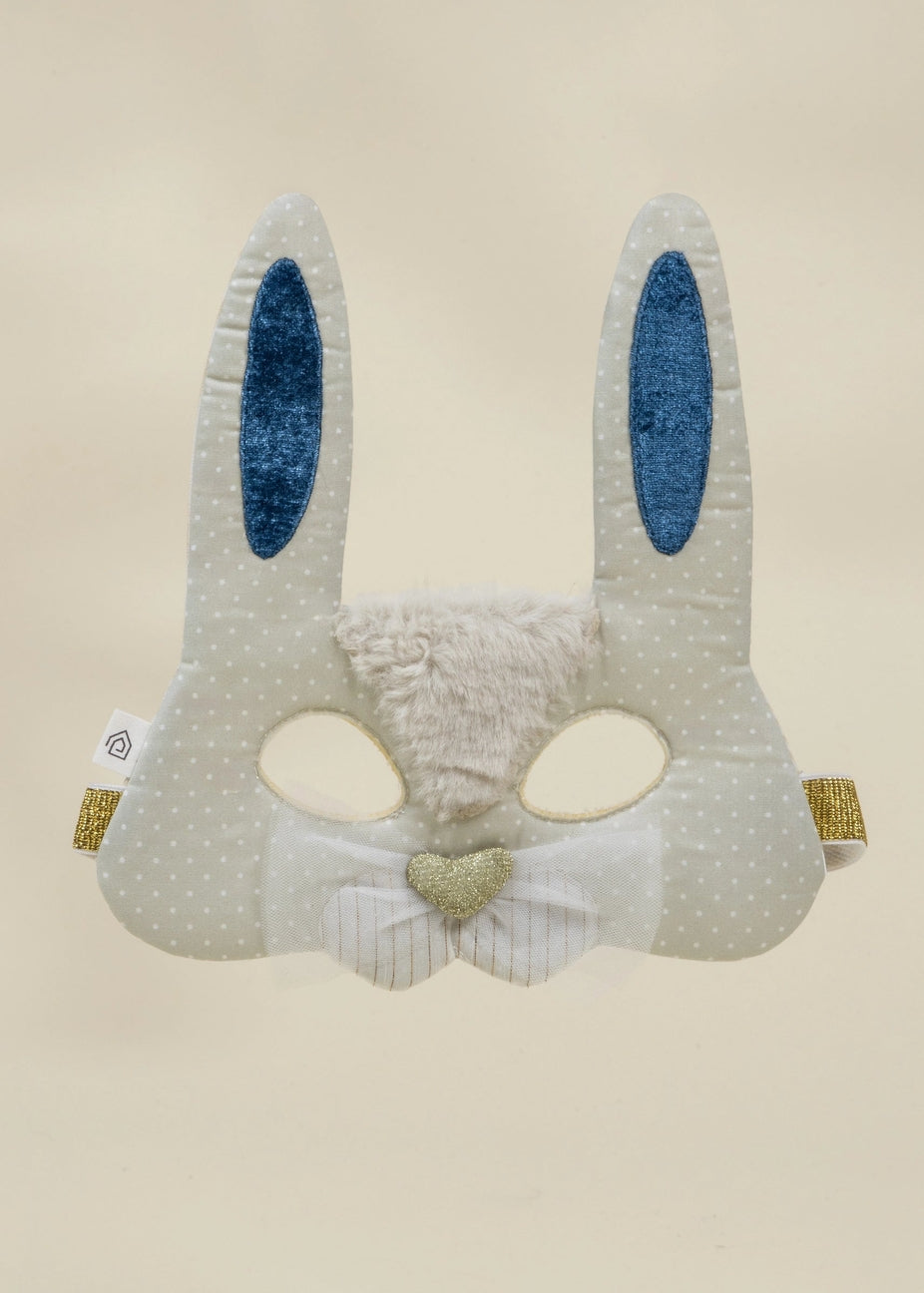 A handmade bunny-themed fabric mask in light gray with white polka dots, featuring blue glittery inner ears, a fuzzy cream nose, and a small gold glitter heart on a bow tie.