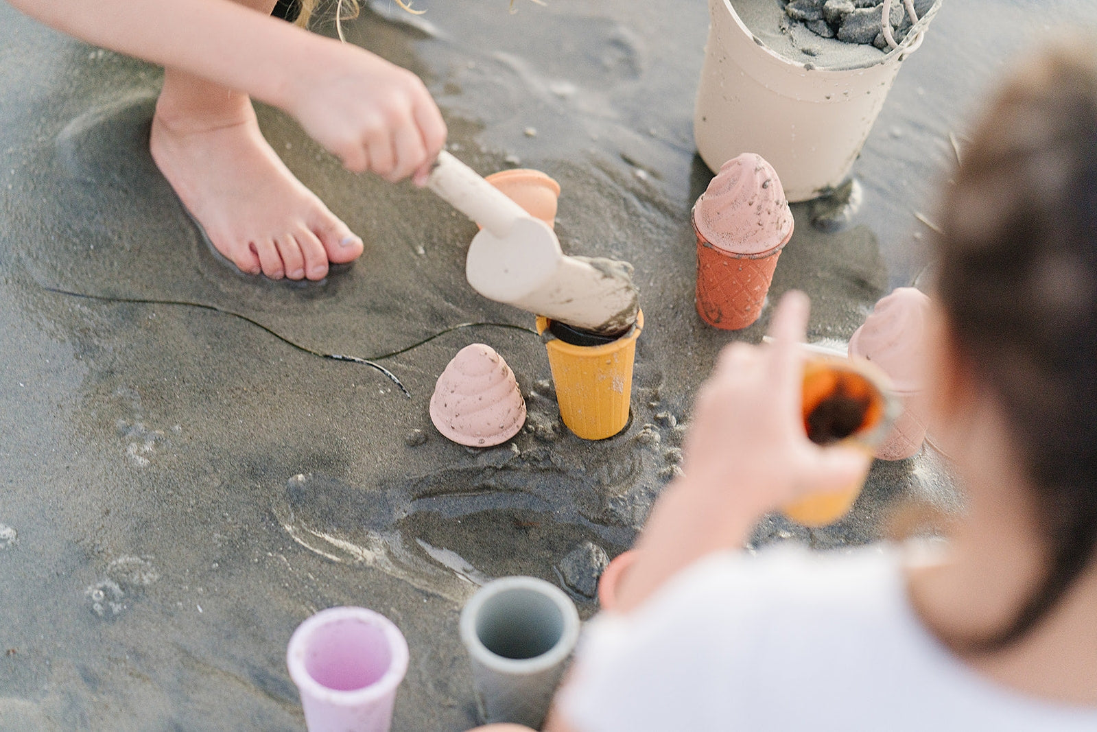 Person playing with sand toys on a beach sand