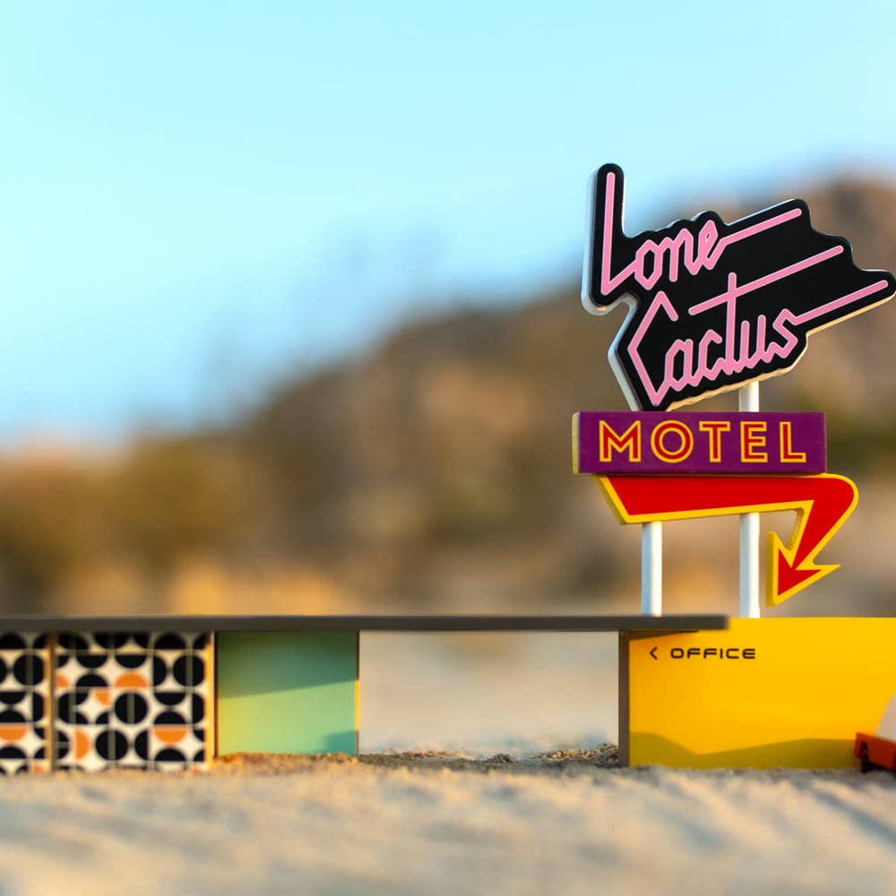 Neon sign for Lone Cactus Motel with a blurred desert background