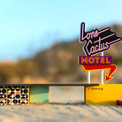 Neon sign for Lone Cactus Motel with a blurred desert background