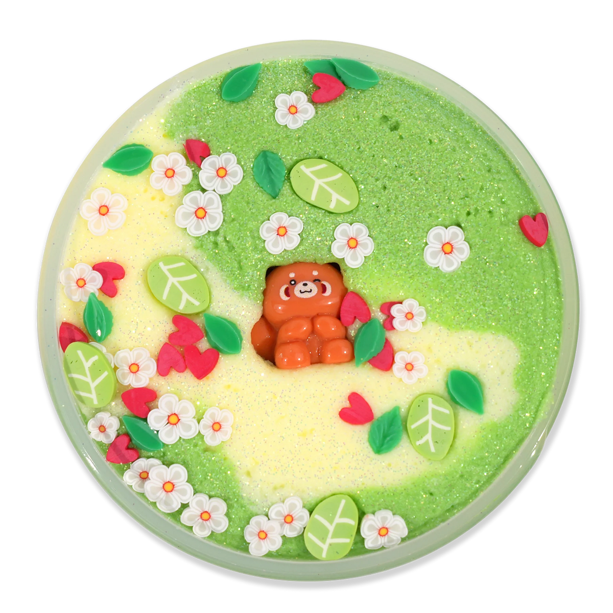 A round decorative dish or tray filled with pastel glittery slime or wax art, featuring a small orange racoon figure in the center, surrounded by green, leaves, flowers, and hearts embellishments on a black background.