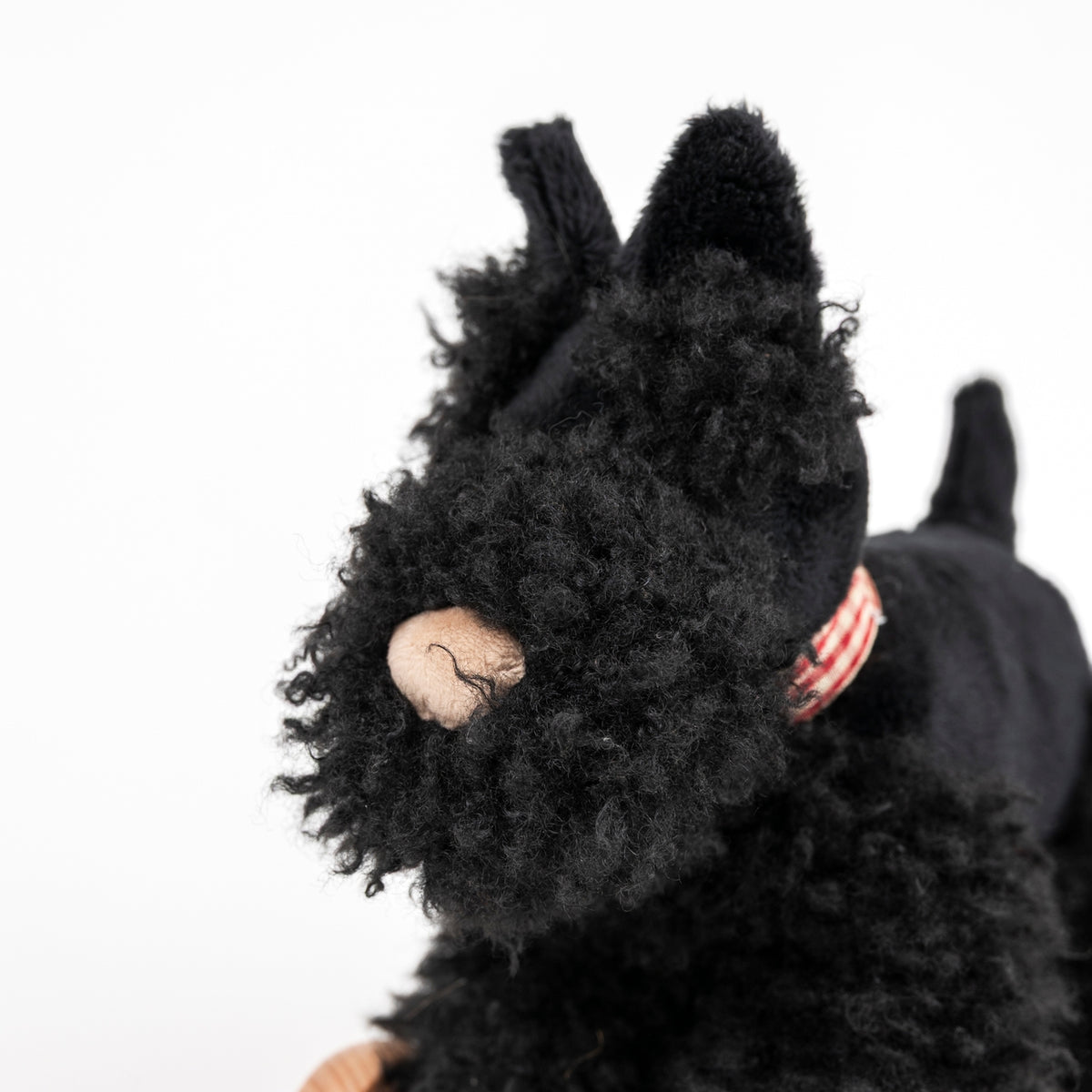 Black plush toy resembling a dog on a white background