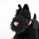 Black plush toy resembling a dog on a white background