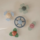 Set of colorful baby teething toys on a light beige background