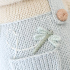 Close-up of a knitted fabric with a dragonfly design and a yarn ball.