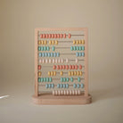 Wooden abacus with colorful beads on a beige background