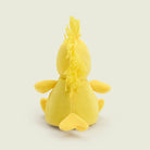 A bright yellow Woodstock Junior by Warmies plush toy viewed from behind, sitting upright against a plain background with its back, tail feathers, and the tuft of feathers on top of its head visible.