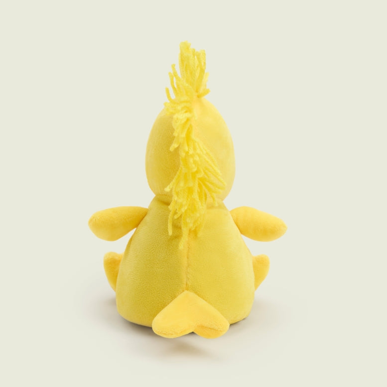 A bright yellow Woodstock Junior by Warmies plush toy viewed from behind, sitting upright against a plain background with its back, tail feathers, and the tuft of feathers on top of its head visible.