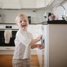 Child in a kitchen holding a smartphone