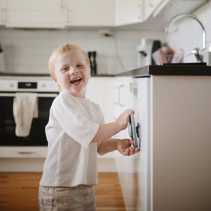 Child in a kitchen holding a smartphone