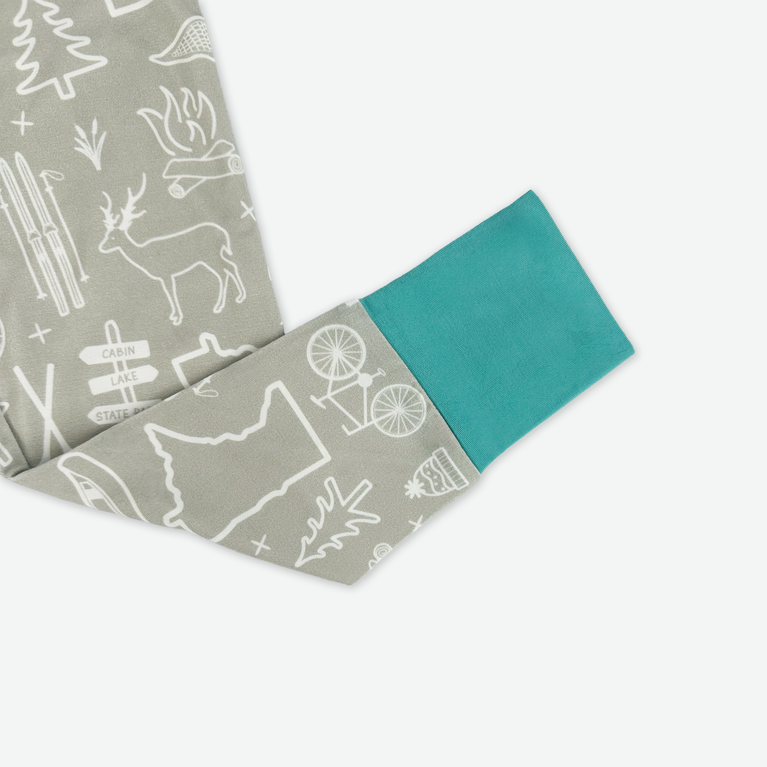 Fabric with nature-themed pattern and teal border on a white background