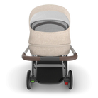 Baby stroller with beige seat and gray cushion on a white background