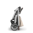 Folded stroller with a beige cover on a white background