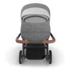 Gray stroller with brown handles on a white background
