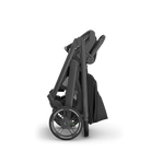 Folded black stroller on a white background