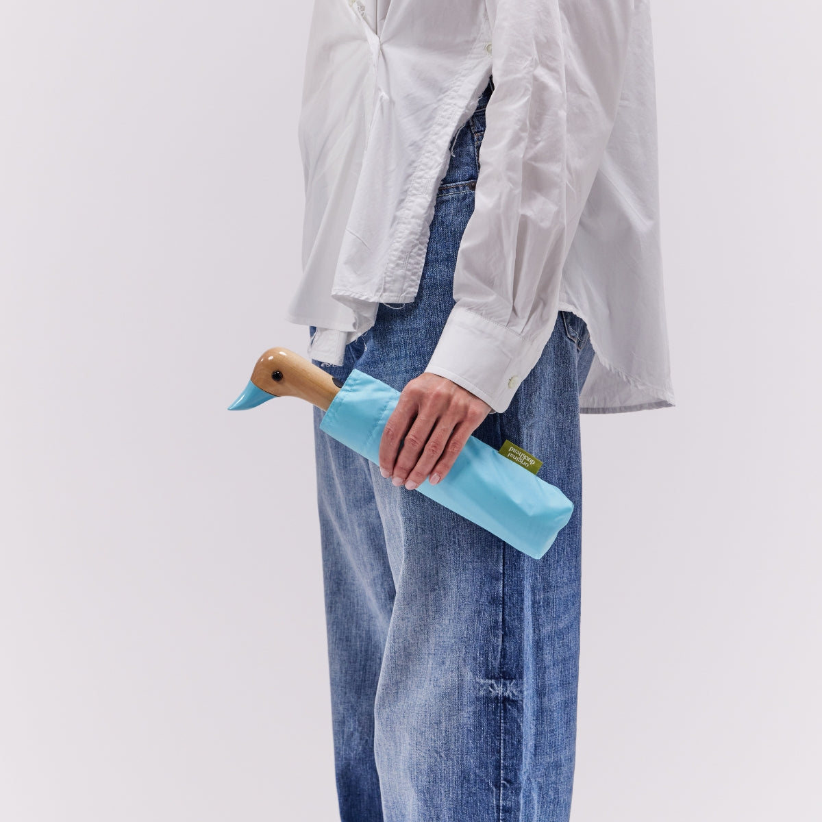 Person holding a blue duck-shaped bottle holder against a plain background