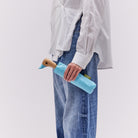 Person holding a blue duck-shaped bottle holder against a plain background