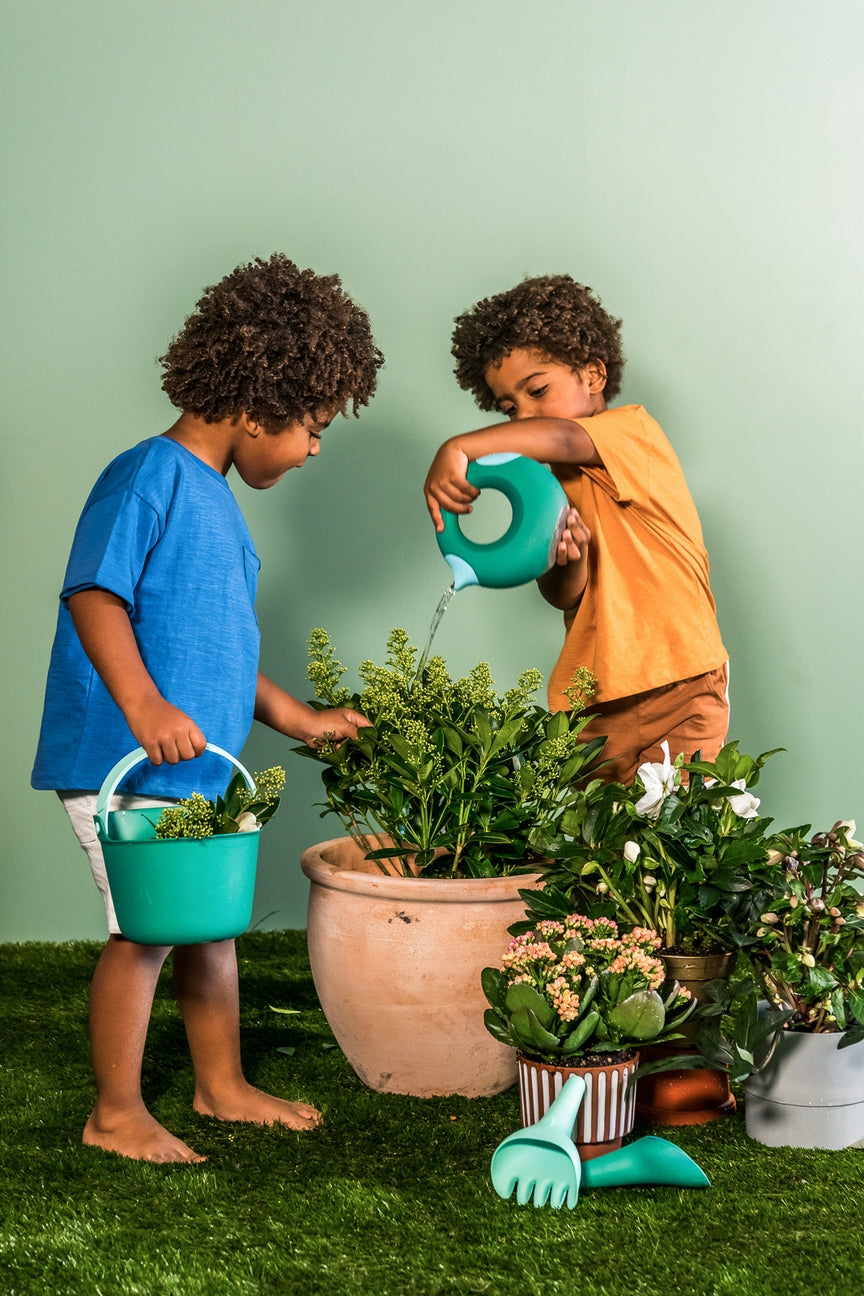 Two children gardening with plants and tools on a green background