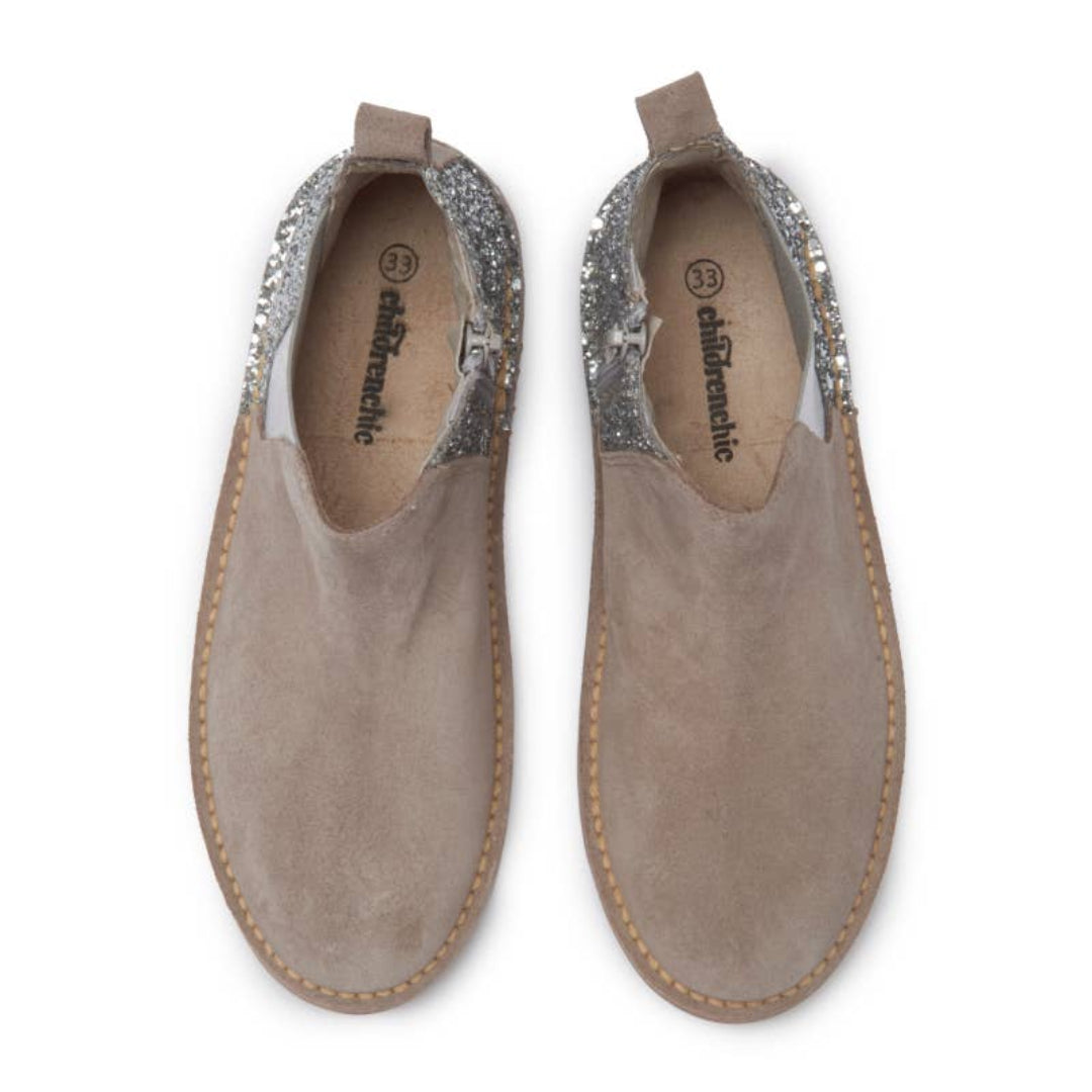 Pair of brown slip-on shoes with glittery embellishments on a white background