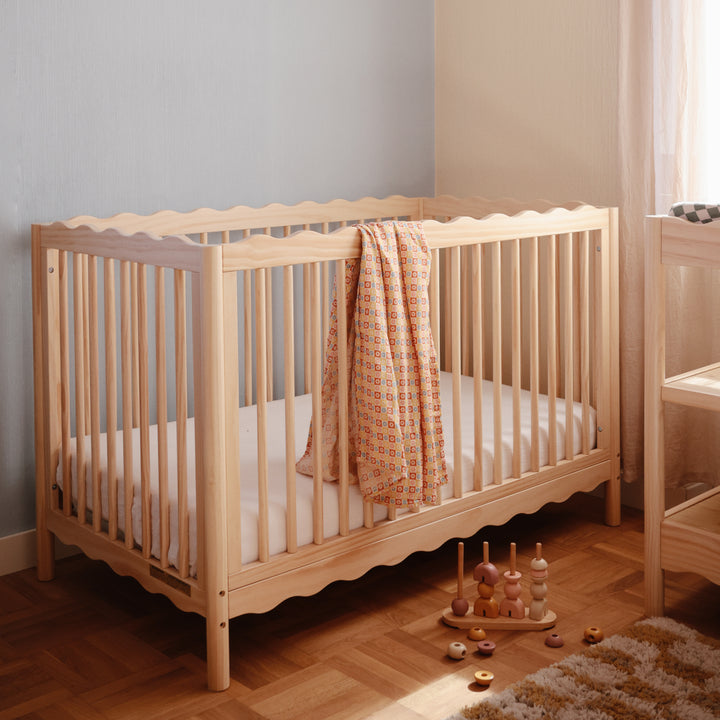 Wooden crib with a blanket in a nursery setting