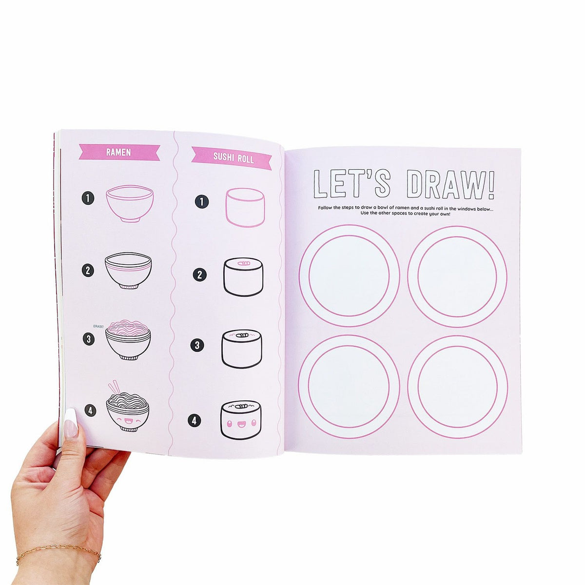 Book open to demonstrate how to draw a sushi roll, held by a hand.