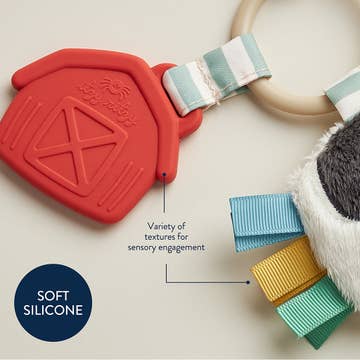 Red silicone teething ring with colorful bands on a neutral background