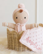 Knitted doll with biege outfit and blanket named 'Sophia' in a basket
