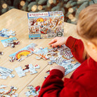 Child playing with a puzzle on a wooden table with a Christmas tree in the background