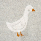 White goose with orange feet and beak on a light gray background
