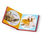 Open book showing illustrations of a turtle and guinea pigs with labels on a white background