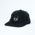 Black corduroy cap with a cat face design on a white background