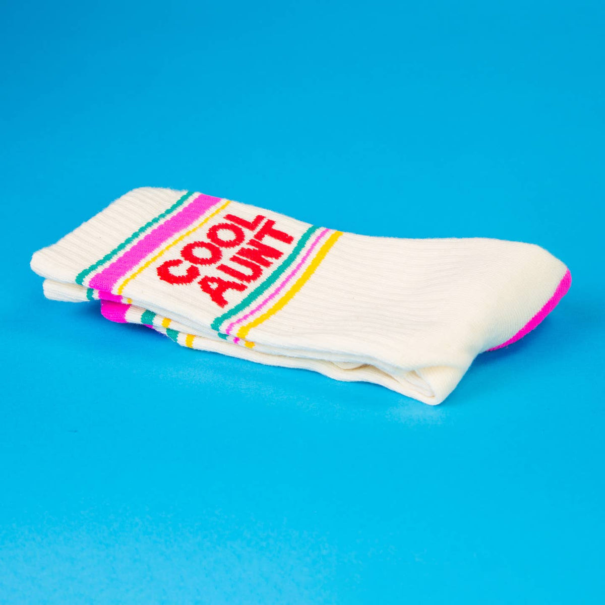Stack of socks with colorful band and 'Cool Aunt!' text on a blue background