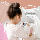 Child using a smartphone with a speech bubble indicating 'Large touchscreen, built for effortless creativity!' in a room with a pink chair and white wall.