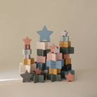 Stack of colorful star and block toys on a beige background