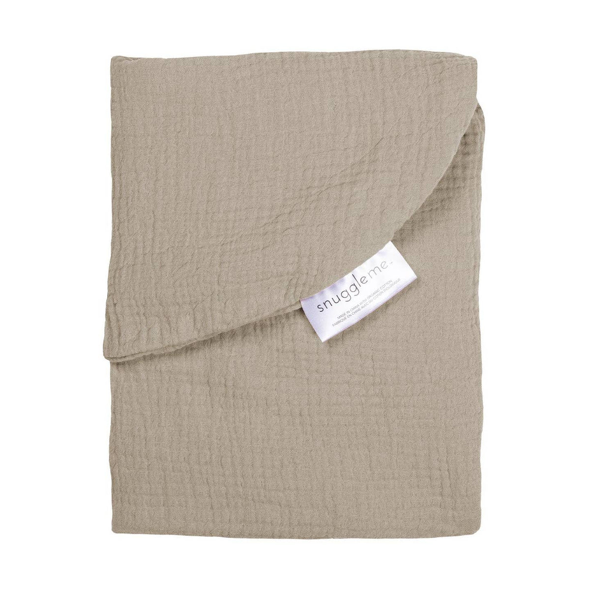 A folded muslin baby blanket in a light taupe-beige color, featuring a white fabric brand tag that reads 'snuggle me'. The blanket is photographed flat on a clean white background.