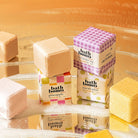 Collection of bath bombs with colorful packaging against a brown background