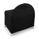 A black room-darkening canopy fitted over an UPPAbaby Remi V2 playard against a dark checkered background.