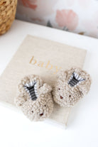 Pair of baby booties on a blanket with 'baby' text