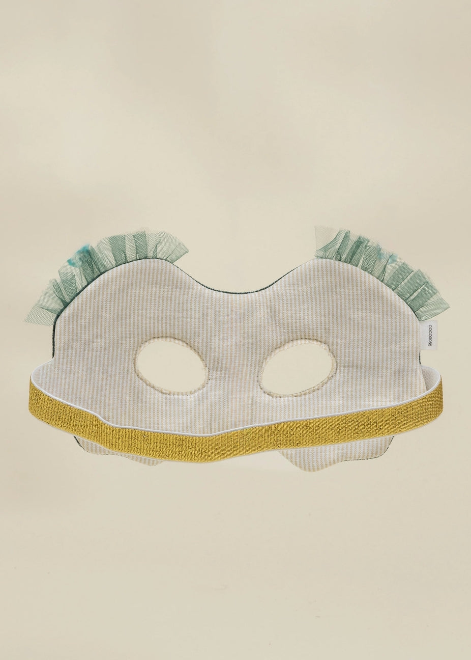 A white and light blue striped fabric mask with a gold glitter trim and ruffled mint green trim at the top, displayed against a plain beige background.