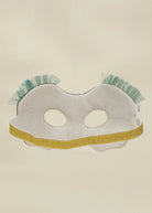 A white and light blue striped fabric mask with a gold glitter trim and ruffled mint green trim at the top, displayed against a plain beige background.