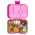 Pink bento box with compartments filled with snacks and fruits on a white background