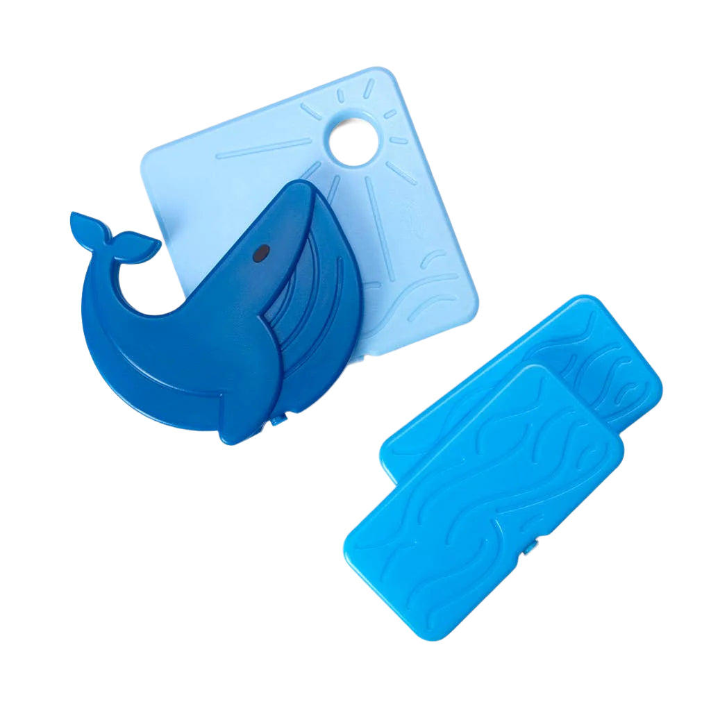 Blue whale-shaped cutting board with additional blue cutting boards on a white background