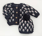 Knitted baby cardigan and hat set with floral pattern on a white background