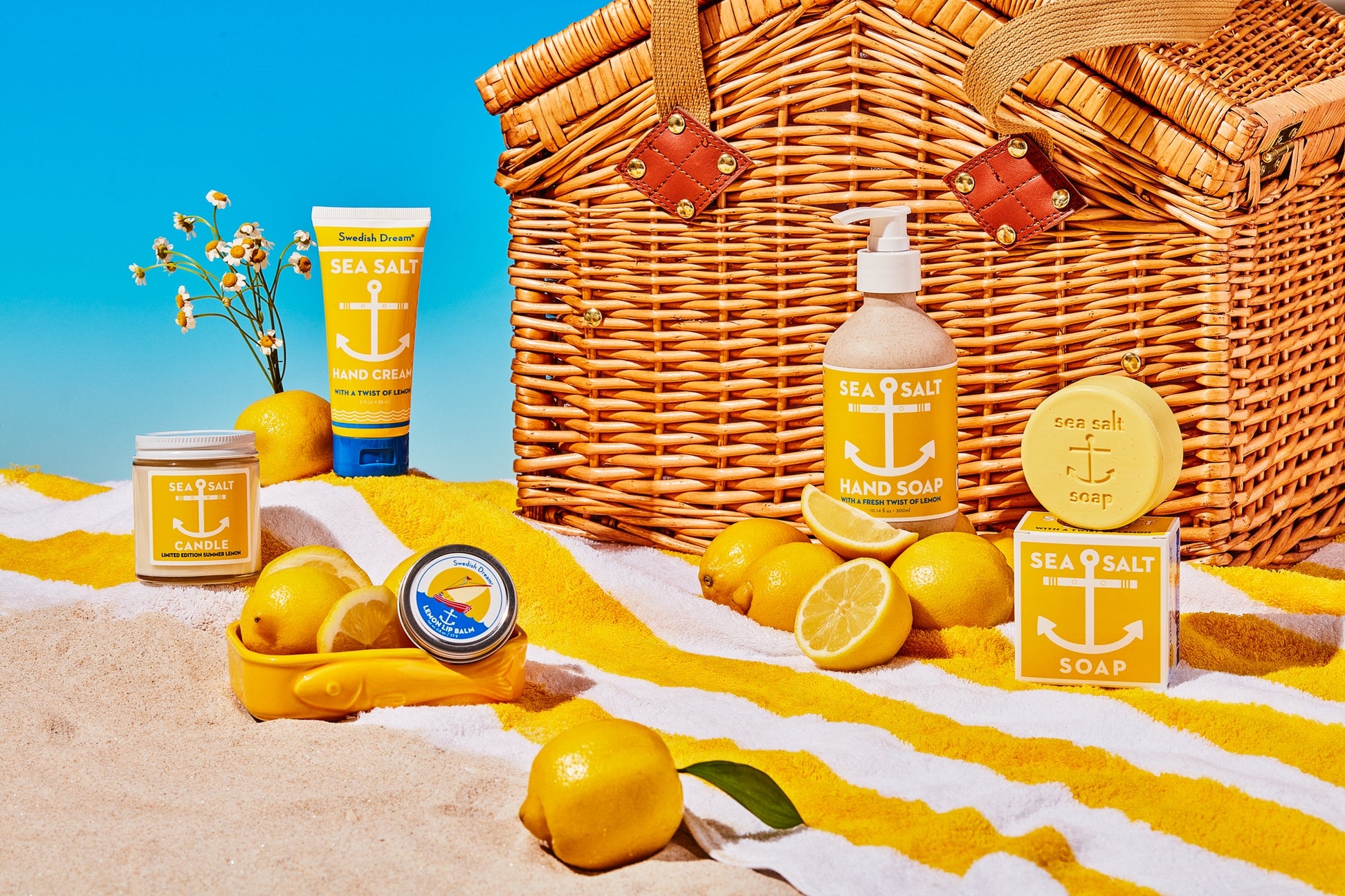 Beach-themed products including a picnic basket, lemons, and beach towels with a clear blue sky.