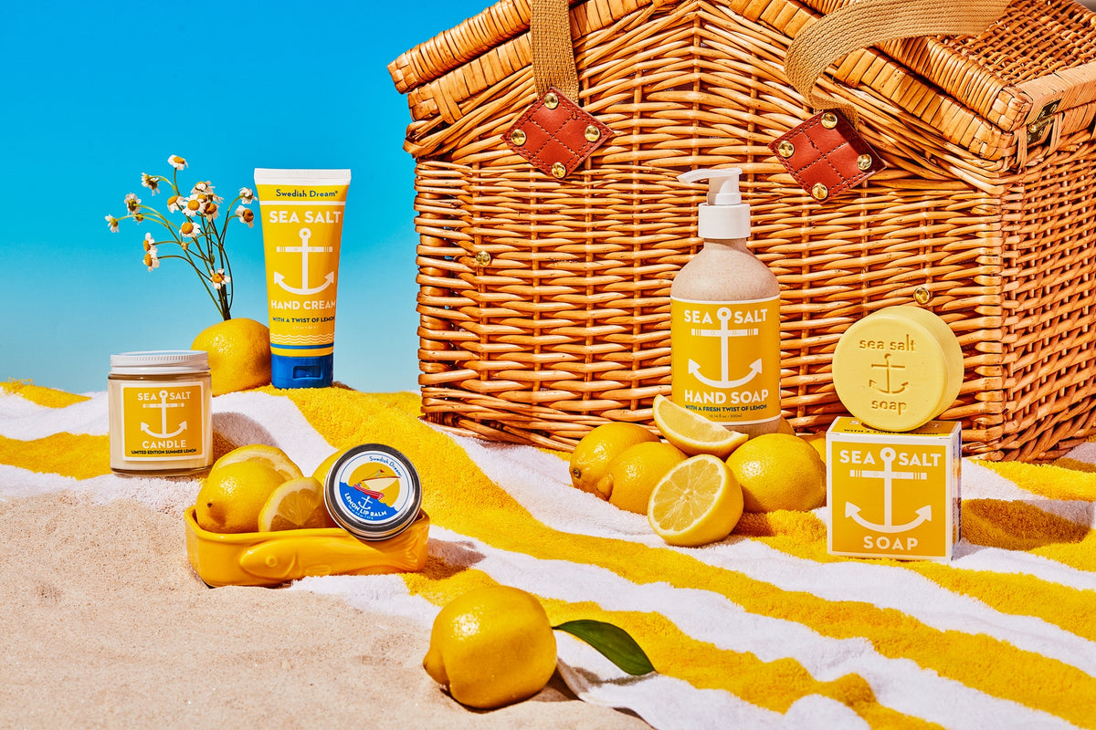 Beach-themed products including a picnic basket, lemons, and beach towels with a clear blue sky.