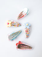 Set of colorful hair clips with decorative elements on a white background