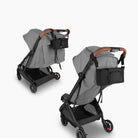 Gray stroller with a black bag on a white background