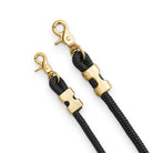 Two black rope straps with gold hardware on a white background